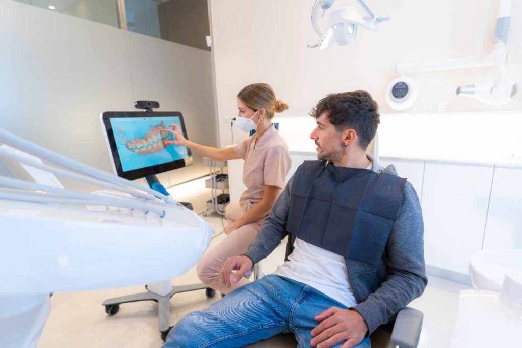 Dentist explaining digital dental images to a patient during a consultation in a modern dental office