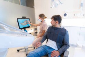 Dentist explaining digital dental images to a patient during a consultation in a modern dental office